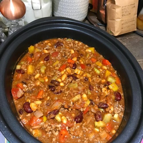 A slow cooker pot full of ingredients ready to make chilli con carne