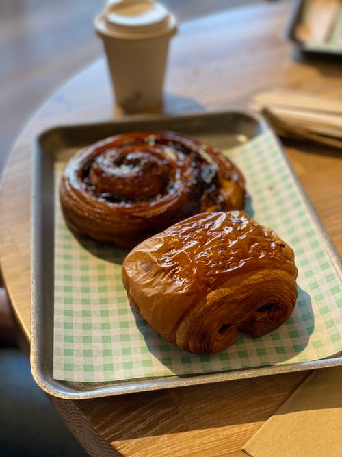 A pain au raisin and pain au chocolate on a metal tray